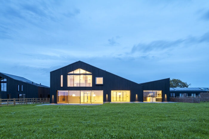 A barn lit up at dusk
