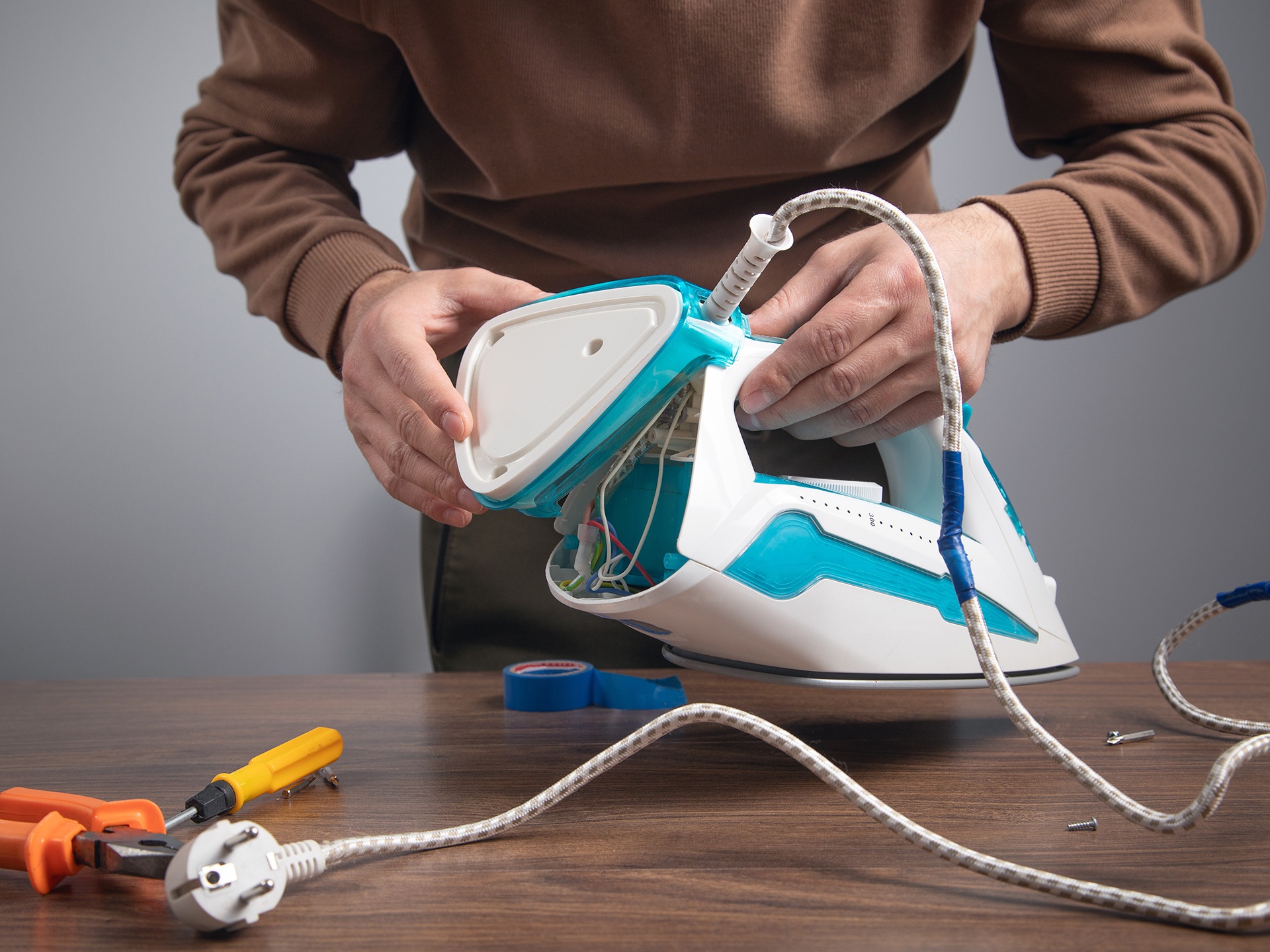 Caucasian man repairing broken iron. Iron repair