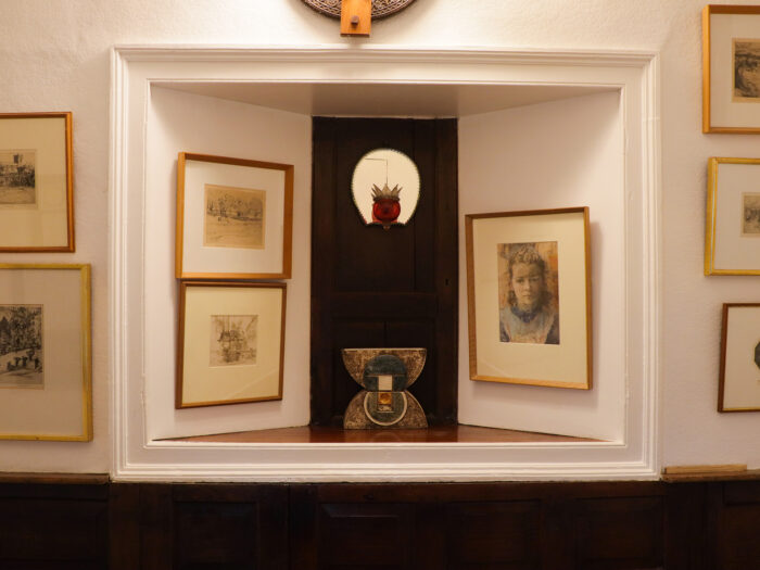The panelled entrance hall containing many pictures and an alcove