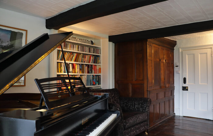 The music room in Nick and Margaret's house with grand piano and wood panelling