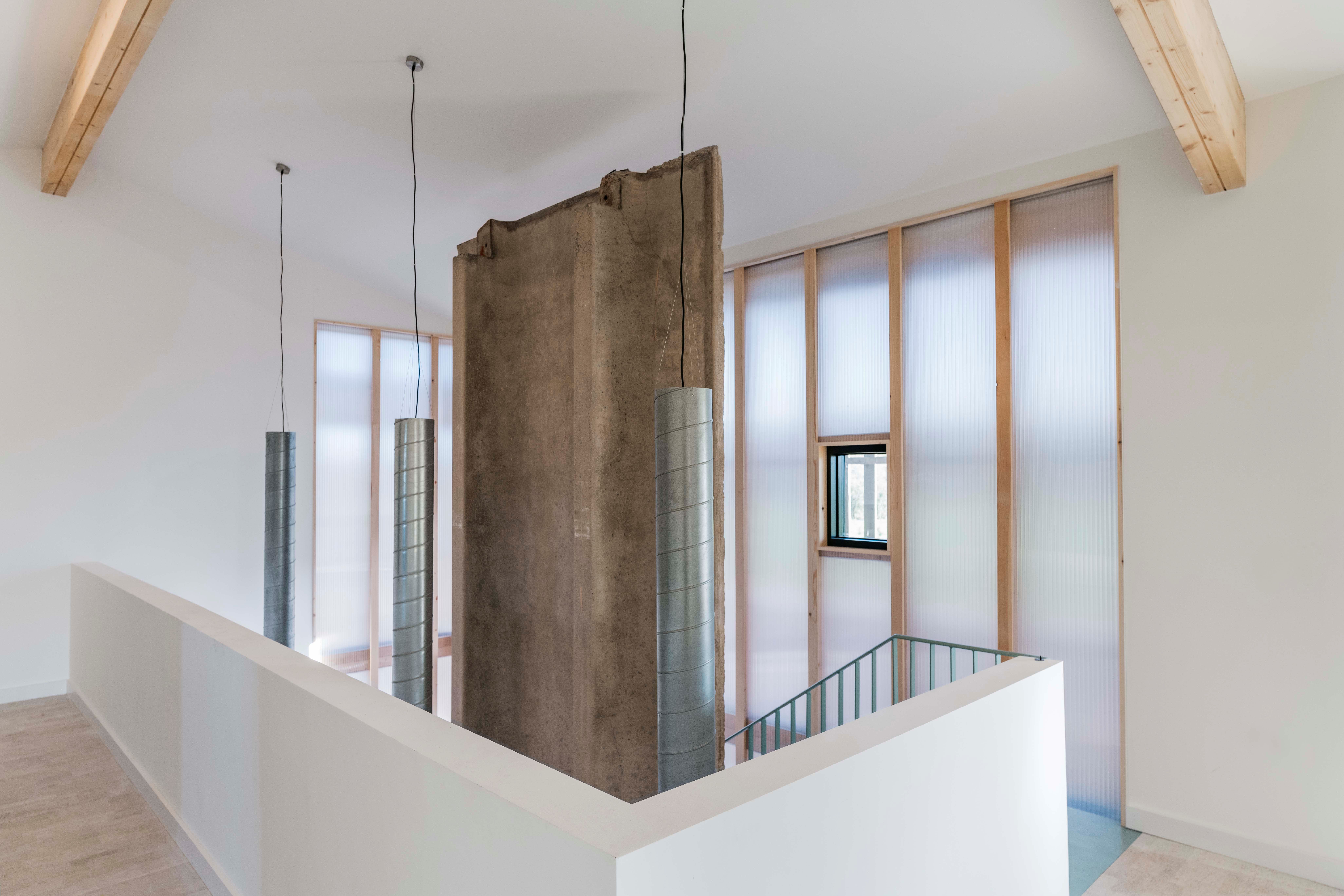 Inside the house, the polycarbonate wall creates a diffuse light. A concrete panels acts as a heat sink and gives a nod to the home's agricultural origins