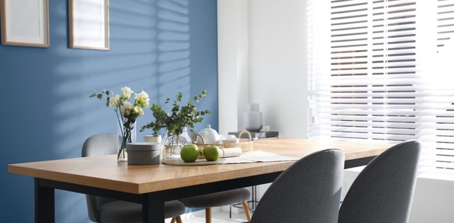 Blue dining space with white wall and blinds
